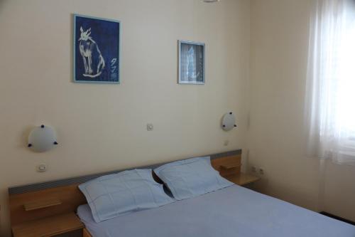 1 dormitorio con 1 cama blanca y 2 almohadas en Green Market Apartment, en Opatija