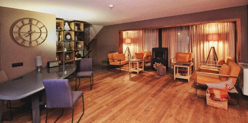 a living room with a table and chairs and a clock at Teghenis Resort in Tsaghkadzor