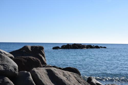 a group of rocks in the water near the ocean at Arion Bay Hotel Santorini in Kamari
