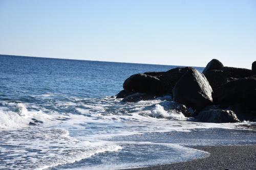 a group of rocks on the beach near the water at Arion Bay Hotel Santorini in Kamari