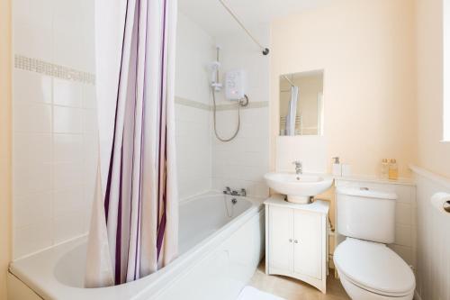 een badkamer met een toilet, een wastafel en een douche bij Well presented 2 bedroom house - sleeps four in Leamington Spa