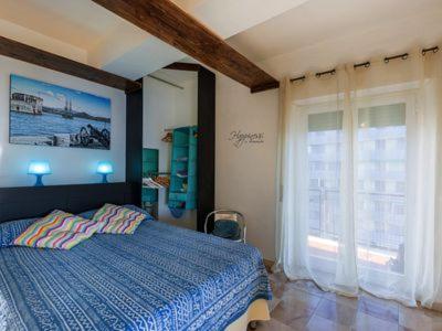 sypialnia z łóżkiem i dużym oknem w obiekcie Loft Vista Mare Elba w mieście Portoferraio