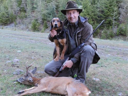 a man is holding a dog and a deer at Hotel Spöl Restaurant in Zernez