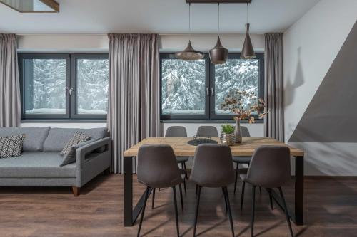 a living room with a dining room table and a couch at Hotel Královka in Bedřichov