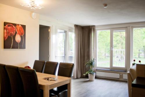a dining room with a table and chairs and a window at De Valkhoeve in Mill