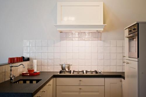 a kitchen with a sink and a stove top oven at De Valkhoeve in Mill