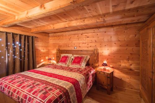 ein Schlafzimmer mit einem Bett in einem Blockhaus in der Unterkunft LE SERRE DE L'AIGLE in Rambaud