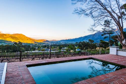 a swimming pool with a view of the mountains at La Petite Ferme in Franschhoek