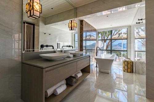 a bathroom with two sinks and a large mirror at La Petite Ferme in Franschhoek
