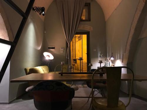 a dining room with a table and a yellow door at La Stratodda Dimora Loft Mare Bandiera Blu 2025 in San Vito dei Normanni