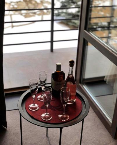 a table with four glasses and a bottle of wine at Teghenis Resort in Tsaghkadzor