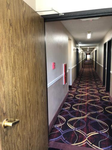 a hallway with a door and a carpeted floor at Super 8 by Wyndham Natchitoches in Natchitoches