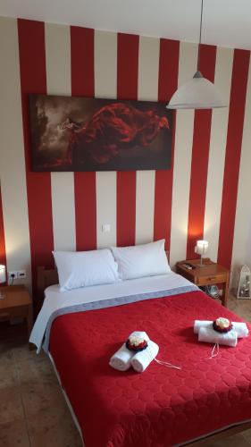 a bedroom with a red and white striped wall at Amalia's Apartments in Kissamos