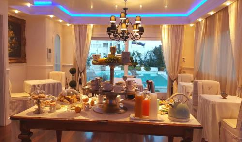 a dining room with a table with food on it at White House Luxury Hospitality in Olbia