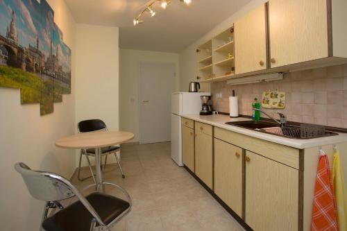 a kitchen with a table and a sink and a table at Ferienwohnung Moritzburg in Boxdorf