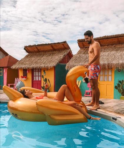 a man standing next to a woman on a dolphin inflatable at Dunas Tatacoa in Villavieja