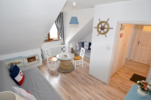 ein Wohnzimmer mit einer Treppe und einem Tisch und Stühlen in der Unterkunft Apartament MORSKA PRZYSTAŃ in Ustka