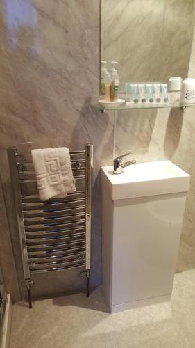 un bagno con un lavandino bianco e uno specchio di Ivanhoe Guest House a Inverness
