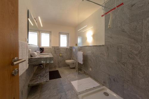 a bathroom with a tub and a sink and a toilet at Alpen Apart Heiss - DELUXE XL Apartments in Prutz