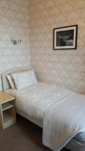 um quarto com uma cama e uma fotografia na parede em Ivanhoe Guest House em Inverness