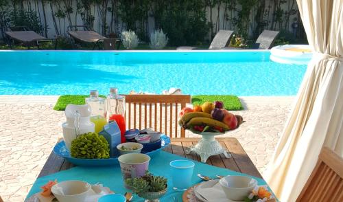 a table with a tray of fruit and drinks next to a pool at White House Luxury Hospitality in Olbia