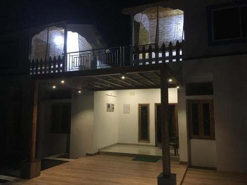 an empty room with a balcony in a building at night at Bleu & Blanc in Puducherry