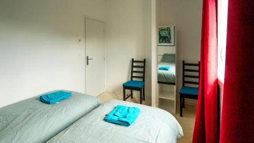 - une petite chambre avec 2 lits et un miroir dans l'établissement Les Terrasses de Cascavelle, à Blauvac