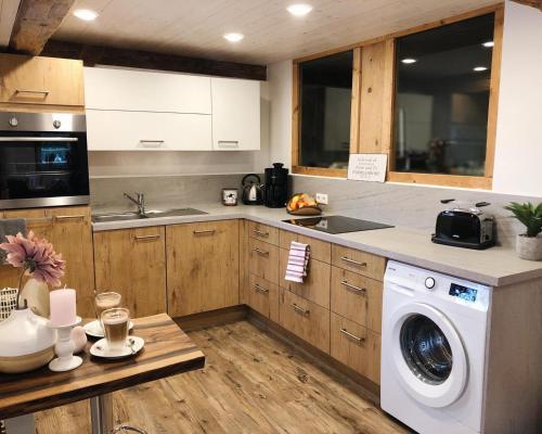 a kitchen with a washing machine and a sink at Ferienwohnung Auszeit in Ausnang in Leutkirch im Allgäu