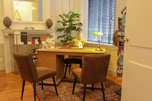 una cocina con una mesa con sillas y una lámpara en Boutique hotel Maison Emile en Amberes