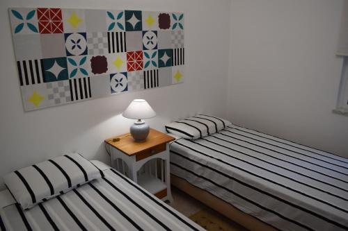 duas camas num quarto com uma mesa e um candeeiro em CasaDuarte Courtyard (1 bedroom Apt.) em Lagos