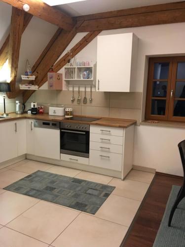 a kitchen with white appliances and wooden ceilings at Ferienwohnung Loh 2 in Dießen am Ammersee