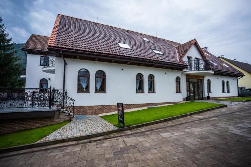 ein weißes Haus mit braunem Dach in der Unterkunft Hotel Palatín in Oravský Podzámok