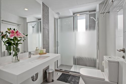 a white bathroom with a sink and a shower at Carihuela Suites in Torremolinos
