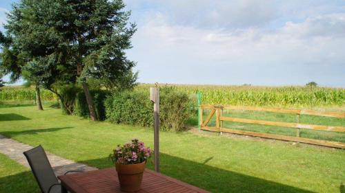 a garden with a table and a fence and a field at Idyllisches Ferienhaus in ruhiger Lage in Wölsickendorf-Wollenberg
