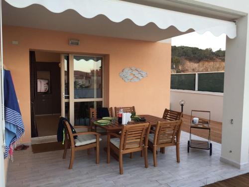 a patio with a wooden table and chairs at Residence Le Terrazze in La Maddalena