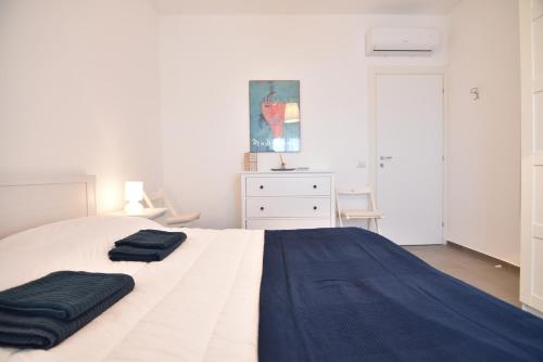 a bedroom with a white bed with two towels on it at Sitting on the beach in Punta Secca