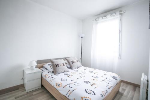 a white bedroom with a bed and a window at Sweet Home Disneyland Paris - Cosy Apartment WiFi in Bussy-Saint-Georges