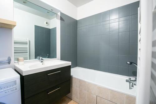 La salle de bains est pourvue d'une baignoire, d'un lavabo et d'un sinkiterator. dans l'établissement Sweet Home Disneyland Paris - Cosy Apartment WiFi, à Bussy-Saint-Georges