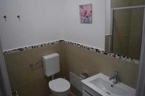 uma casa de banho com um WC e um lavatório em CasaDuarte Courtyard (1 bedroom Apt.) em Lagos