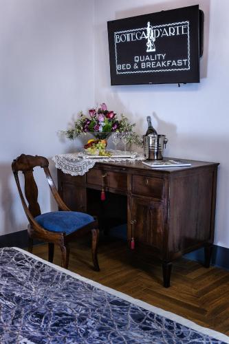 a wooden desk with a chair and a sign on the wall at B&B "La Bottega d'Arte" in Carrara