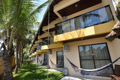 a building with hammocks on the side of it at Hotel Kima in Bombinhas