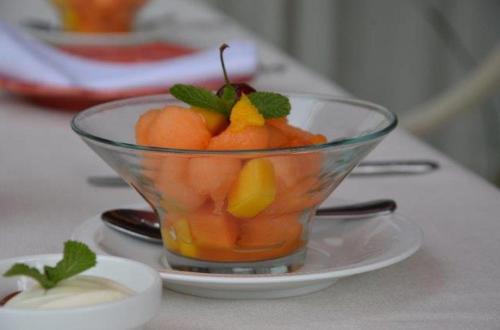 a glass bowl of fruit on a plate on a table at Andre's Place in Durban
