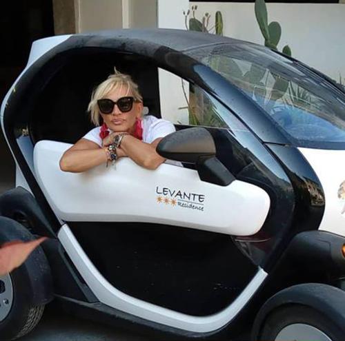 a woman is sitting in a car at Levante Residence in La Spezia