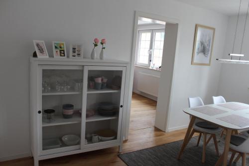 a white cabinet in a room with a table at Ferienwohnung in herrlicher Lage in Bad Urach