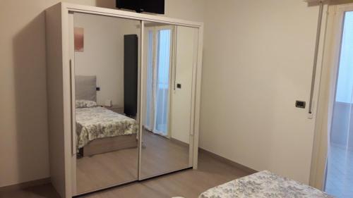einen Spiegel in der Ecke eines Zimmers mit einem Schlafzimmer in der Unterkunft Appartamento Aurora in Malcesine