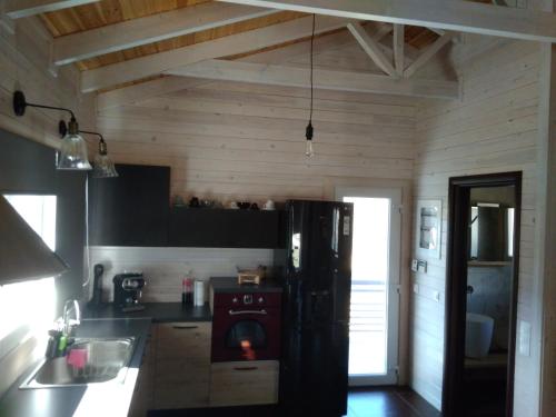 eine Küche mit einem schwarzen Kühlschrank im Zimmer in der Unterkunft Atmospherico in Karpenisi