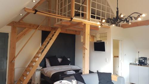 a loft bed in a room with a bed and a ladder at Casaprisco in Putten