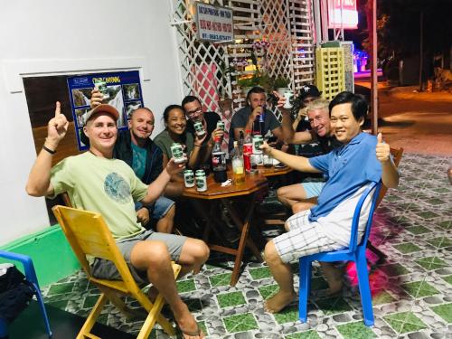 a group of people sitting around a table with beers at Minh Duc Hotel - Phan Rang in Phan Rang