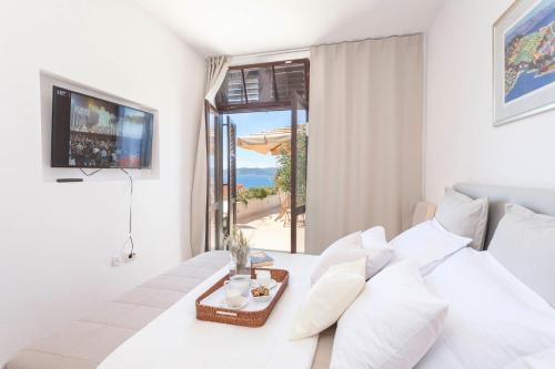 Schlafzimmer mit einem weißen Bett und Meerblick in der Unterkunft Guesthouse Mate Ledic in Brela
