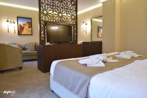 a hotel room with a bed with towels on it at Sahara Hotel in Svilengrad